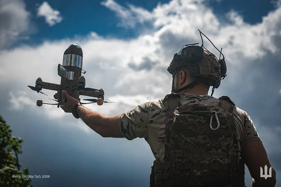 A Ukrainian soldier launching a Wild Hornets Sting interceptor drone by hand